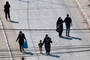 فلسطينيون في الشارع بعدما أخلوا منازلهم بسبب العملية العسكرية في جنين السبت (رويترز)